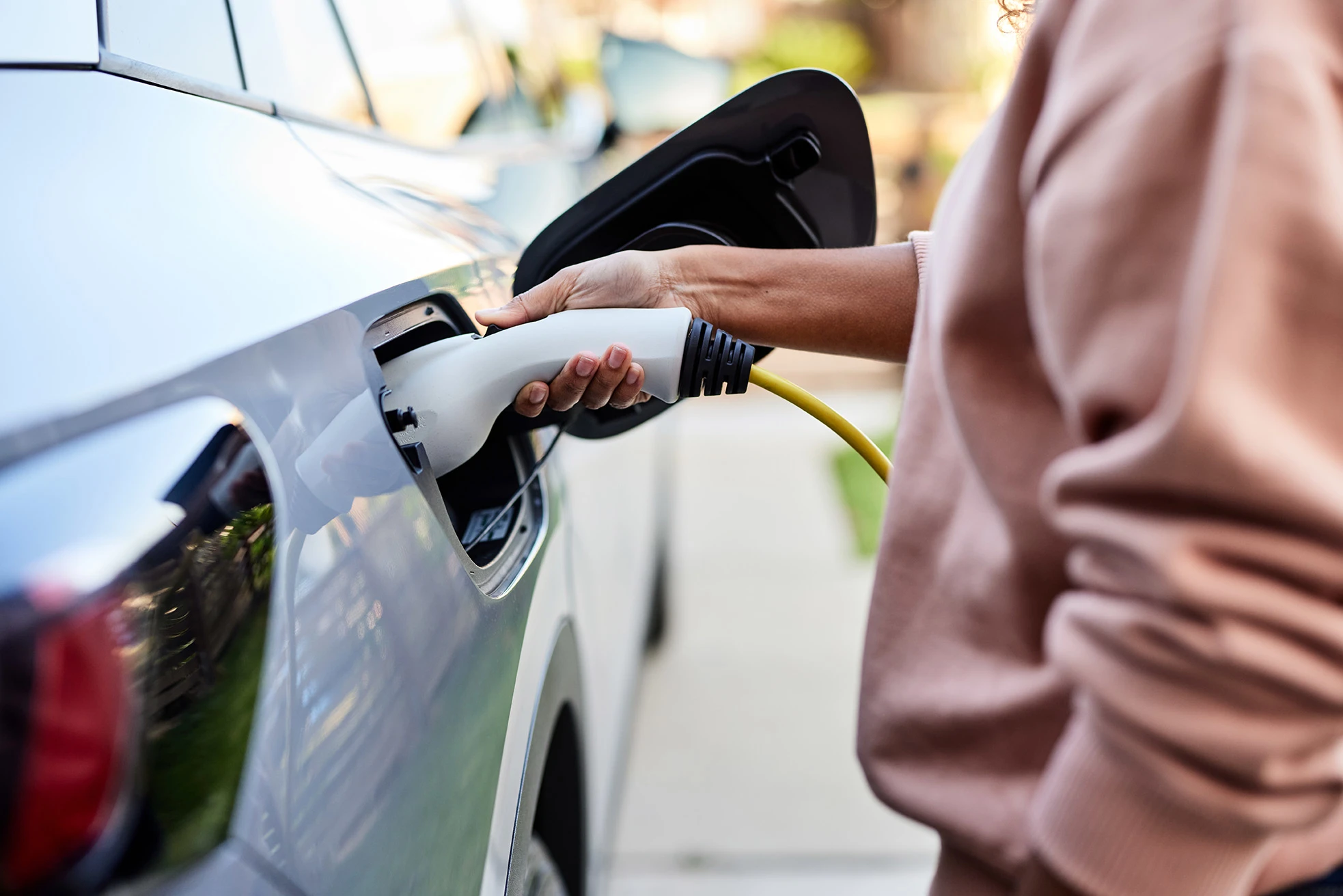 Close up image of a person plugging in an EV