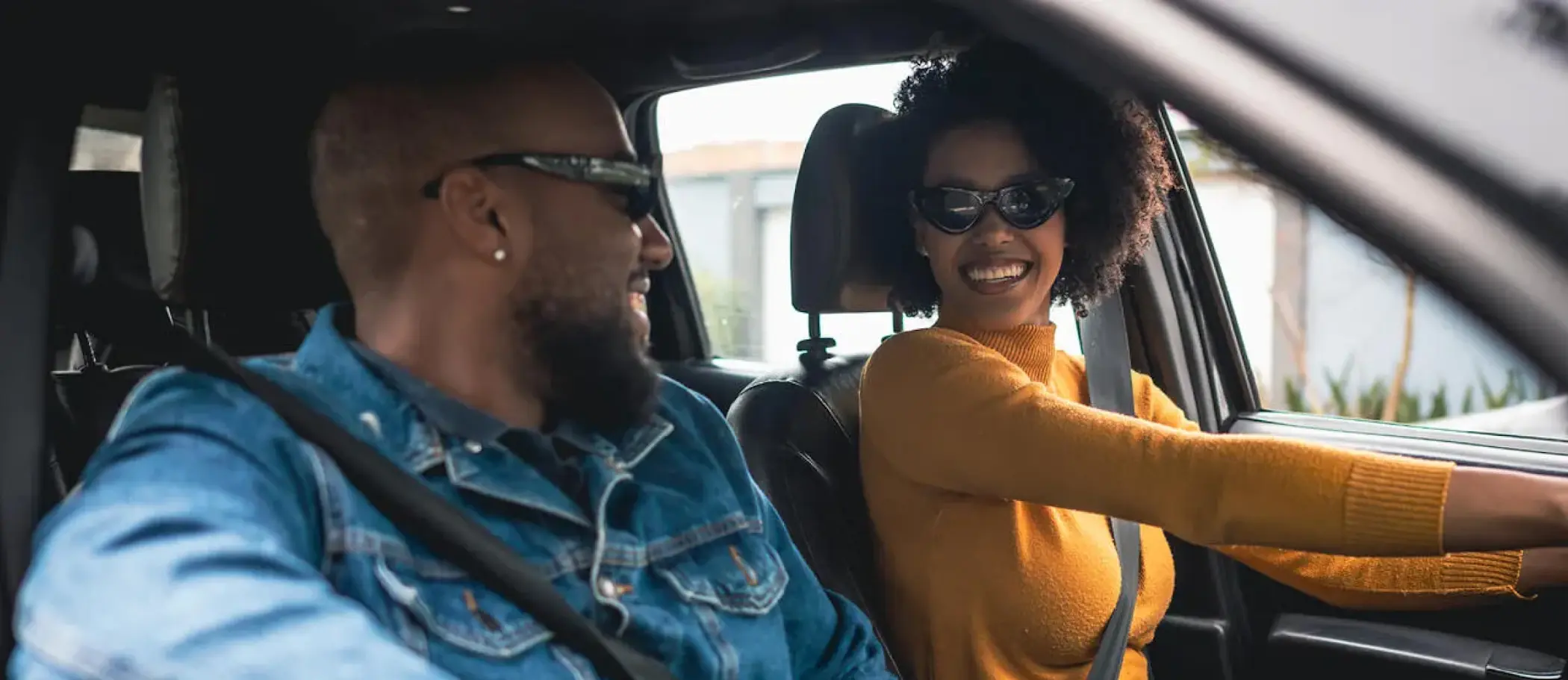 Man and Woman sitting in SUV laughing together