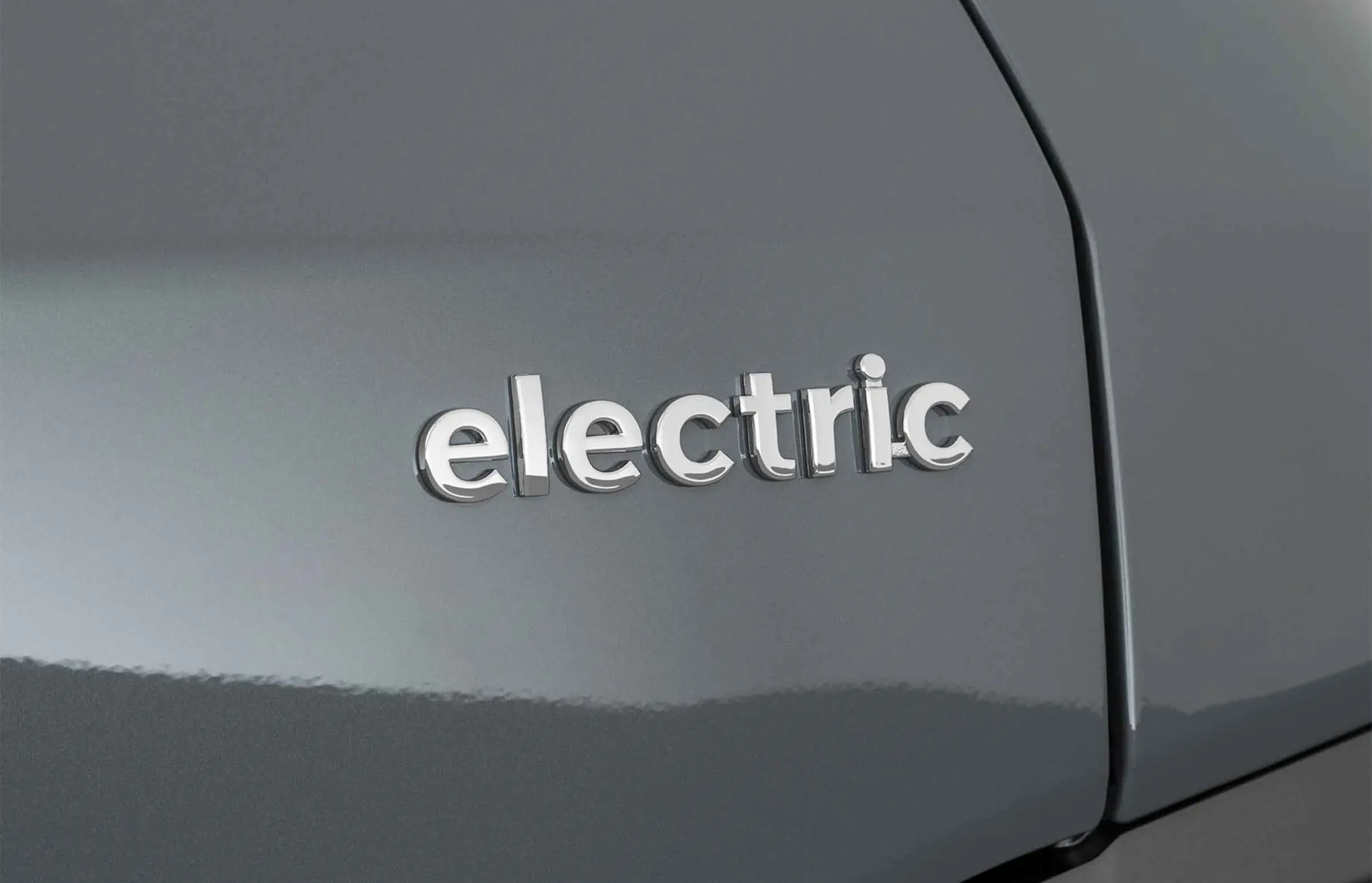 Close-up of the word 'Electric' displayed on the rear of a grey car
