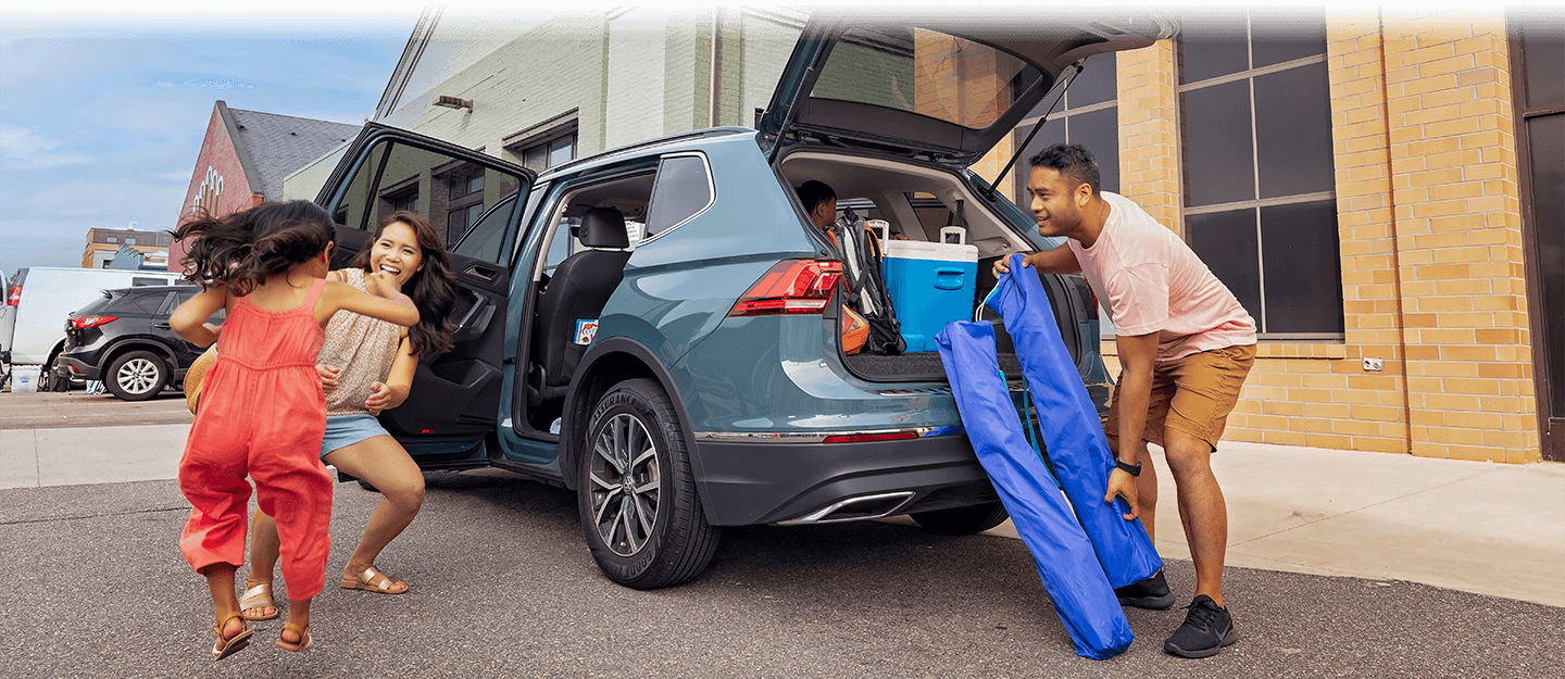family loading their blue SUV