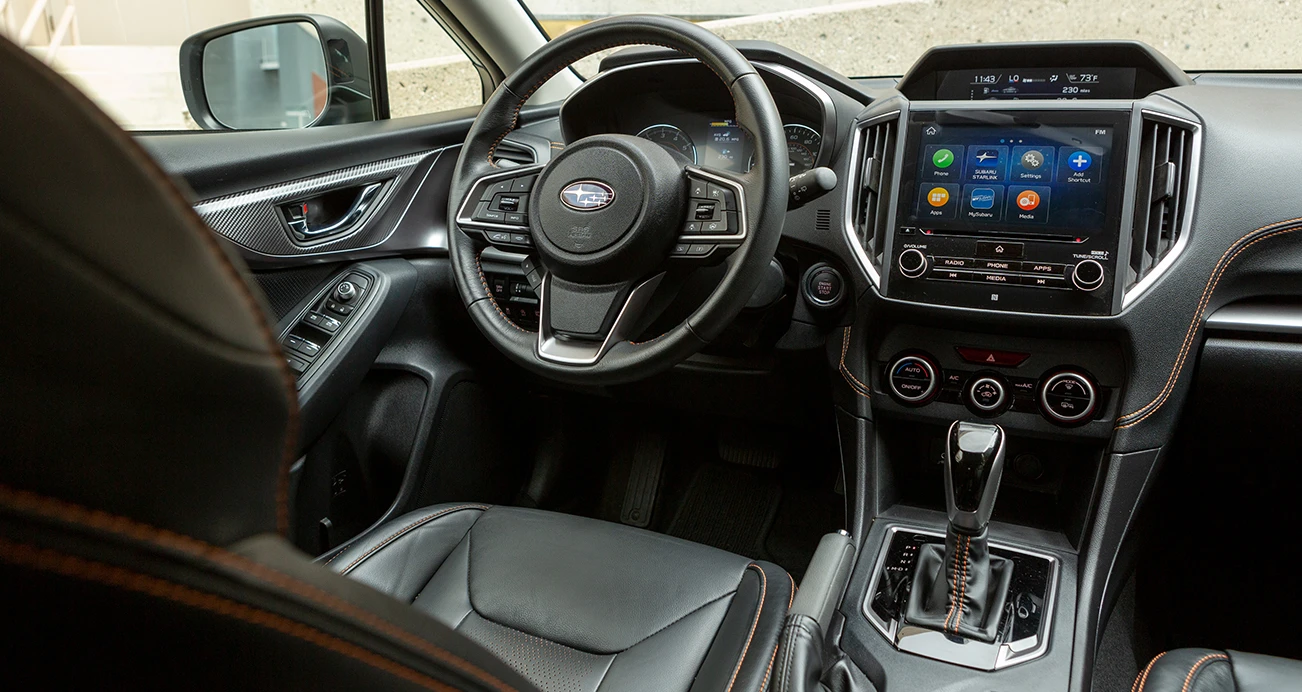 Interior view of a 2022 Subaru Crosstrek's black leather driver seat, dashboard and steering wheel 