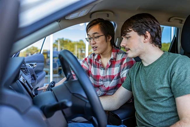 How to Test Drive a Car: Two men casually looking dashboard while test driving a car | CarMax