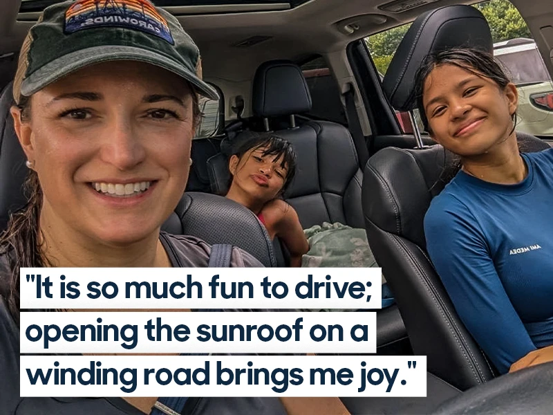 Family of three smiles while sitting inside of their Subaru Ascent. Quote overlaid on photo reads "It is so much fun to drive; opening the sunroof on a winding road brings me joy."