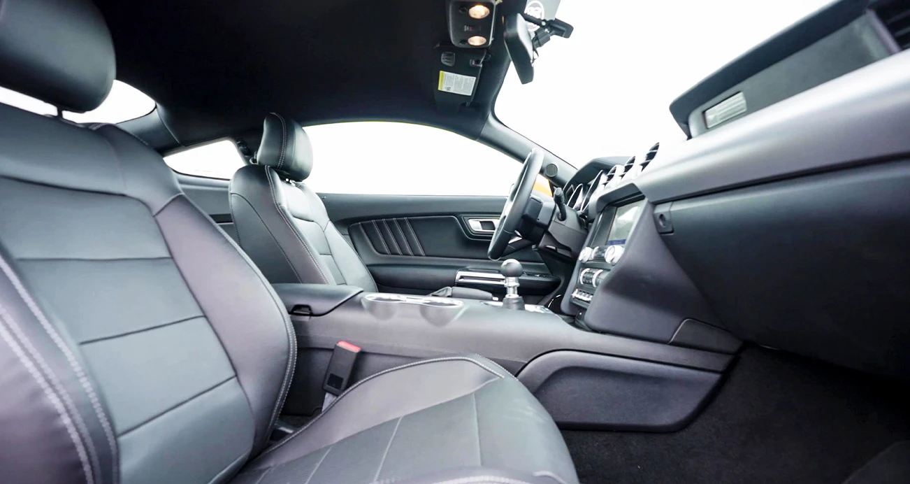 Interior of a Mustang displaying driver and passenger black leather seats 