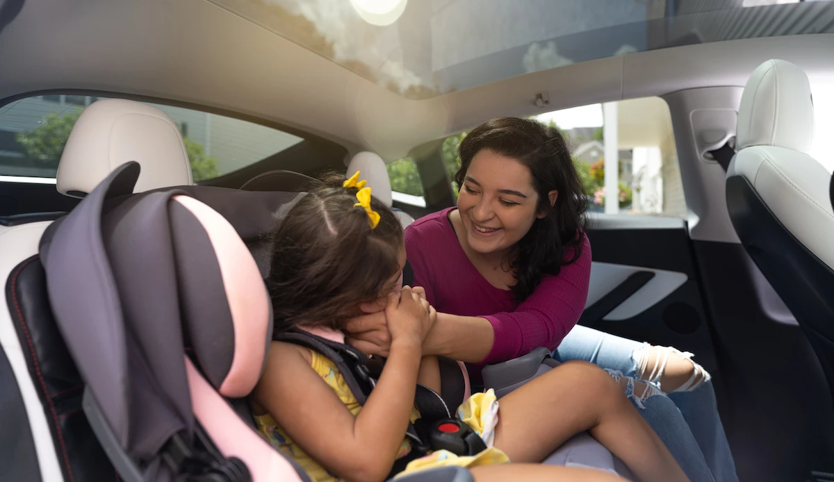 Mother and daughter in backseat of Tesla