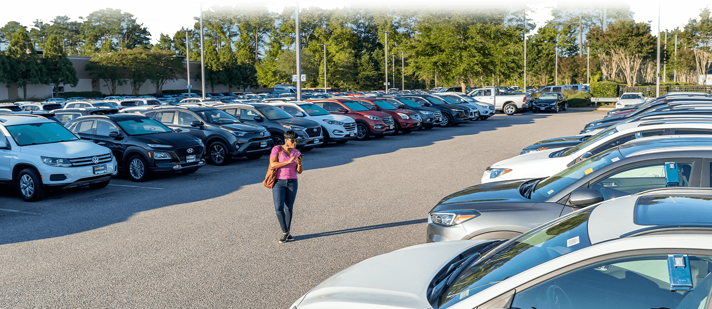 Woman shopping for a car walking the outdoor lot at CarMax