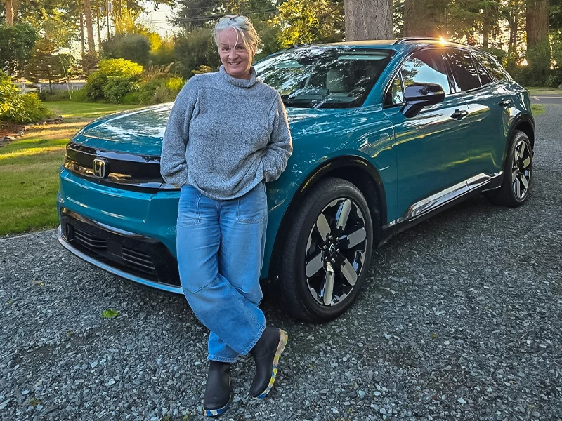 Alyssa Royse leaning on the front of her blue 2024 Honda Prologue 