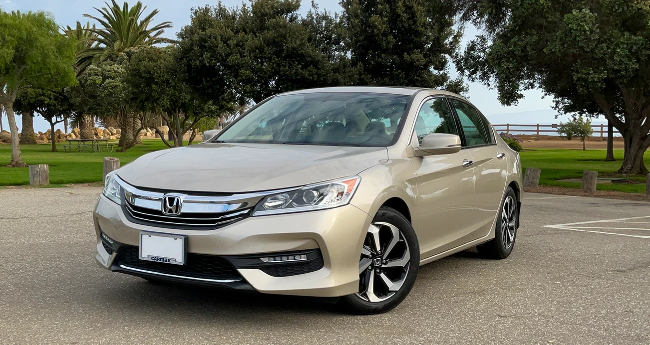 Front view of a gold ninth-generation Honda Accord sedan 2013-2017 parked in a parking lot
