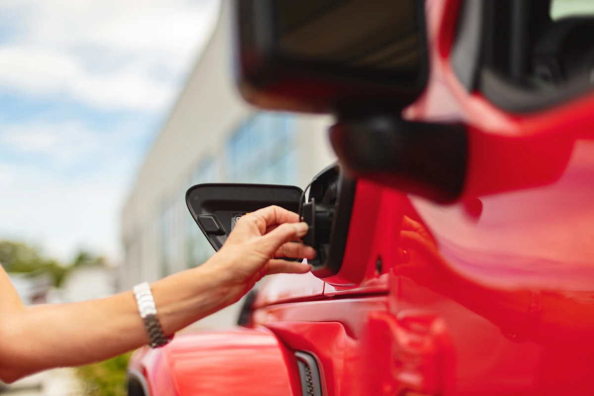 Person opening charging door on Jeep Wrangler plug-in hybrid