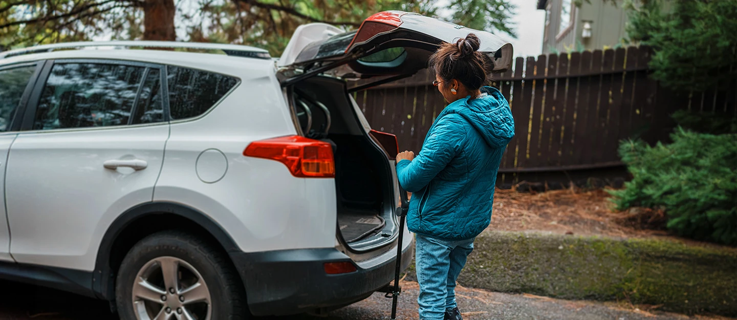 Lady opening the trunk of her white SUV