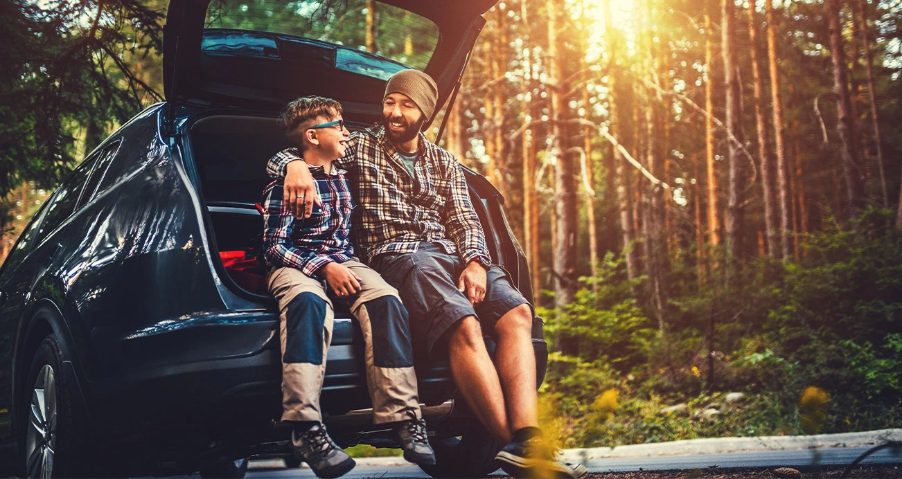 127 Best Used Cars for 2022: Father and son sitting in trunk of SUV | CarMax