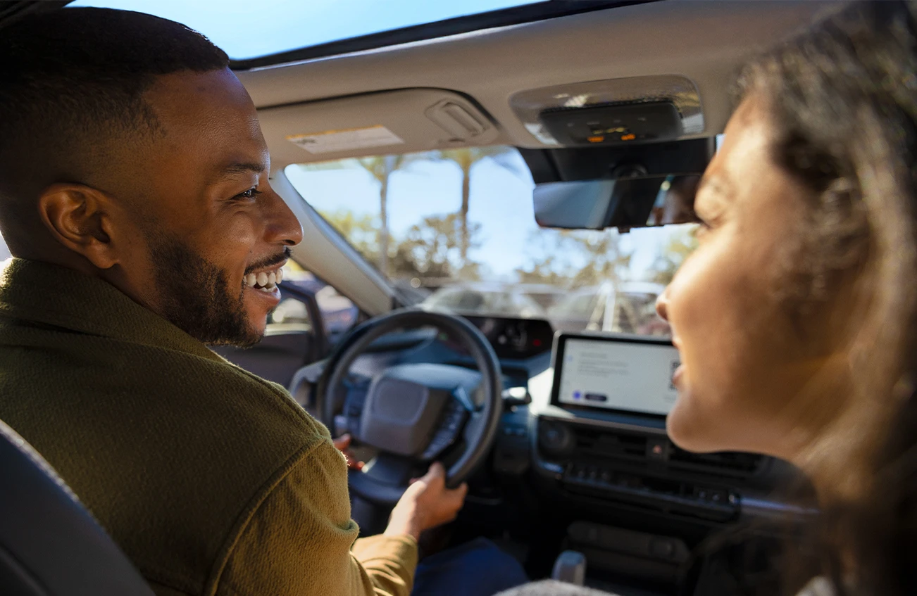 Man smiling at his passenger from drivers seat