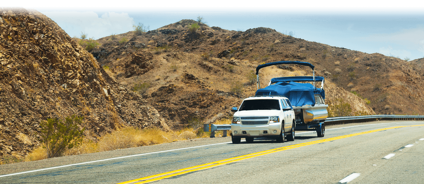 SUV driving along road towing boat