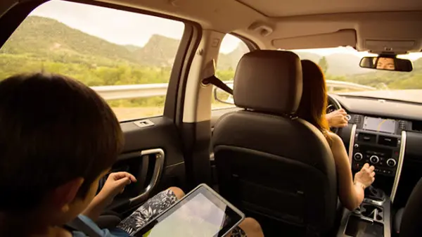 Child with tablet in second row of SUV