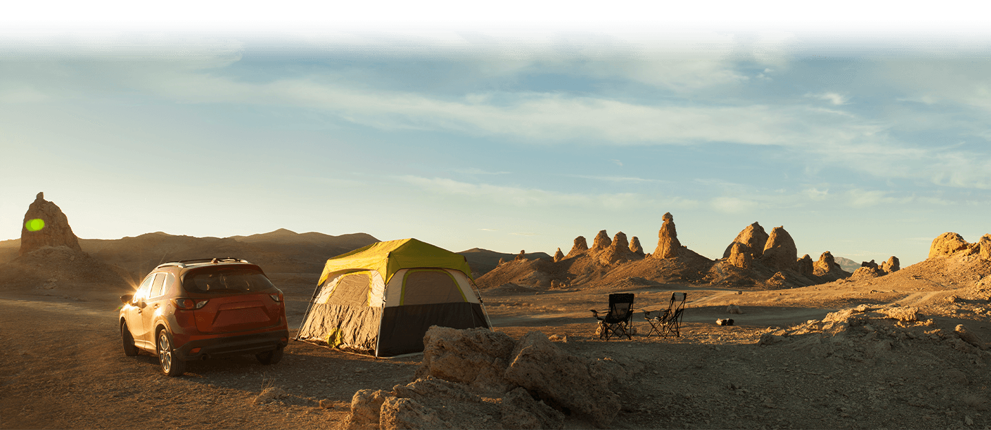 AWD vehicle parked beside tent in desert camping area